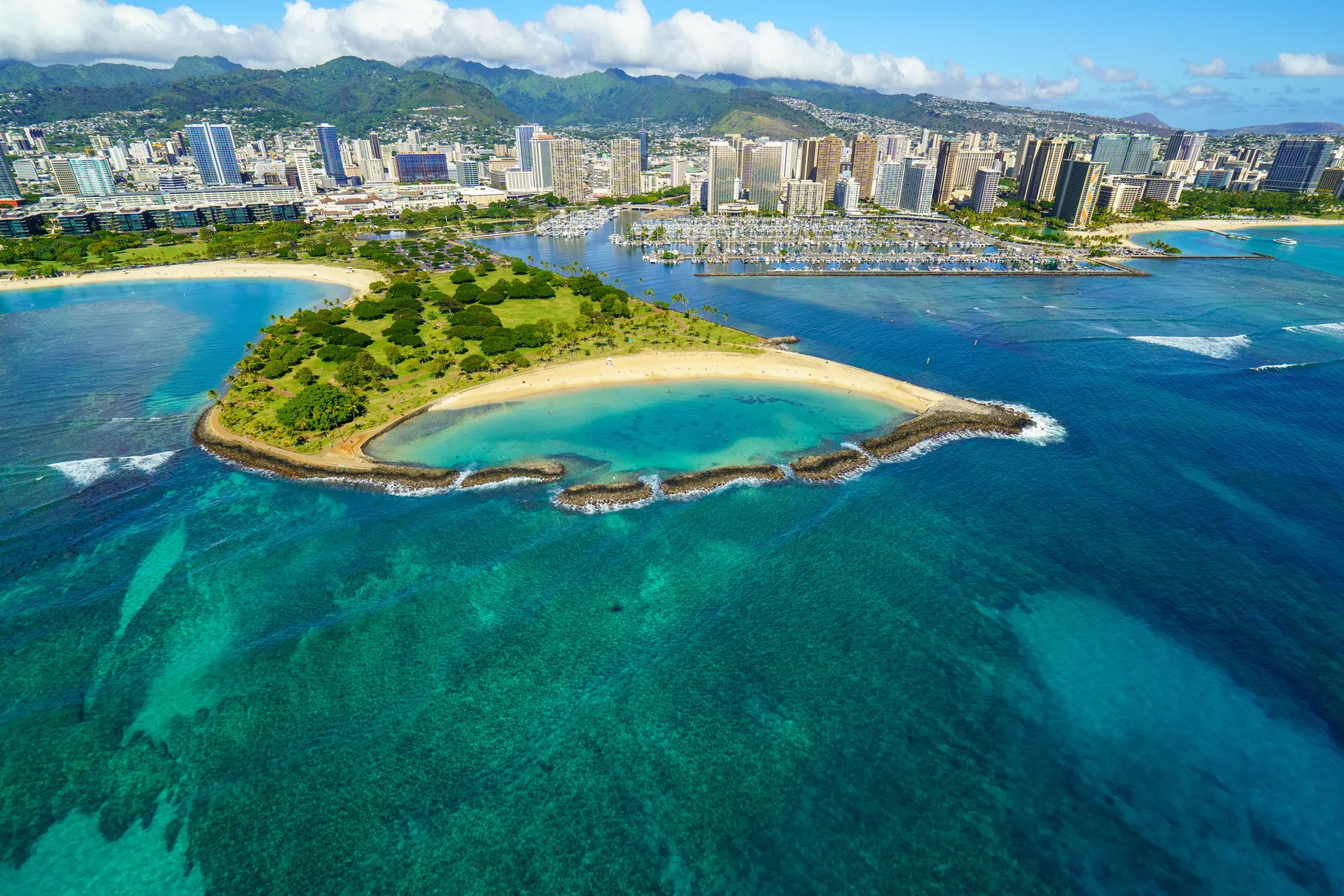 Stunning aerial view of Honolulu's coastline with beaches, skyscrapers, and turquoise waters.